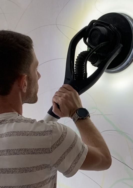 Arthur en plein travail qui ponce un mur